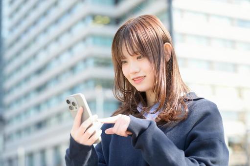 スマホを指差す女子高生 スマホを指差す女子高生 スマホ,高校生,女子高生の写真素材