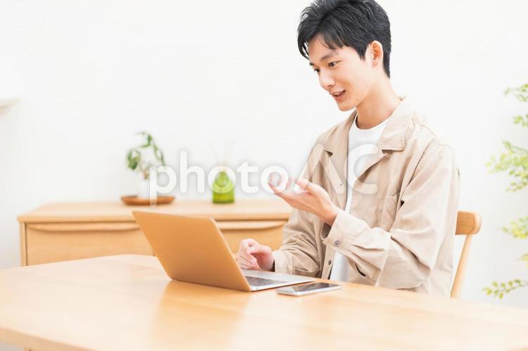 パソコン作業をしながら電話をする男性 男性,ビジネスマン,学生の写真素材
