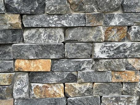 グレーとオレンジの石を組み合わせた壁 石,石壁,壁の写真素材