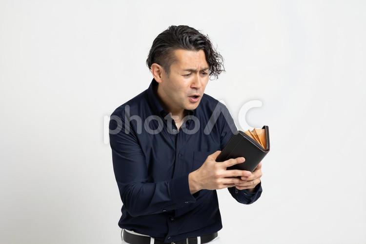 財布を見てがっかりする男性 ハーフ,スペイン人,日本人の写真素材