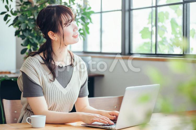 キッチンの前でパソコンを使う女性（笑顔） パソコン,女性,テレワークの写真素材