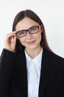 メガネのフレームを持つカメラ目線の女性 女性,外国人,メガネの写真素材