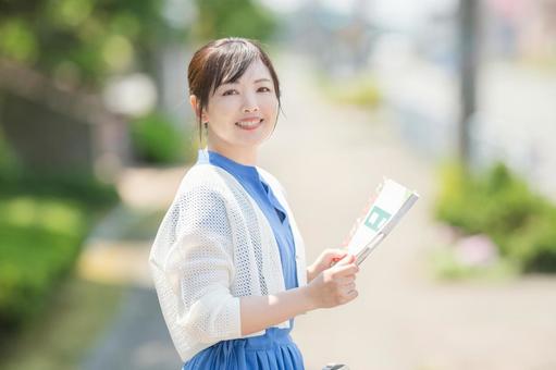 笑顔でガイドブックを持つ女性 笑顔でガイドブックを持つ女性 女性,笑顔,ガイドブックの写真素材
