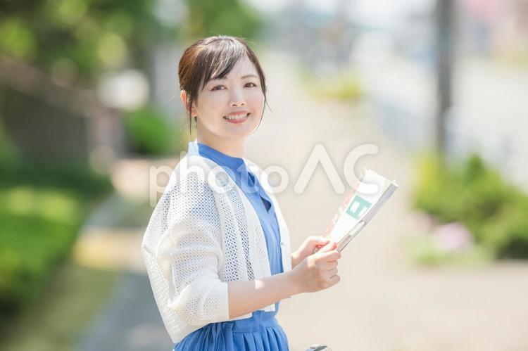 笑顔でガイドブックを持つ女性 女性,笑顔,ガイドブックの写真素材