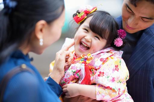 着物姿の幼い娘を抱きしめる両親の笑顔 着物姿の幼い娘を抱きしめる両親の笑顔の写真