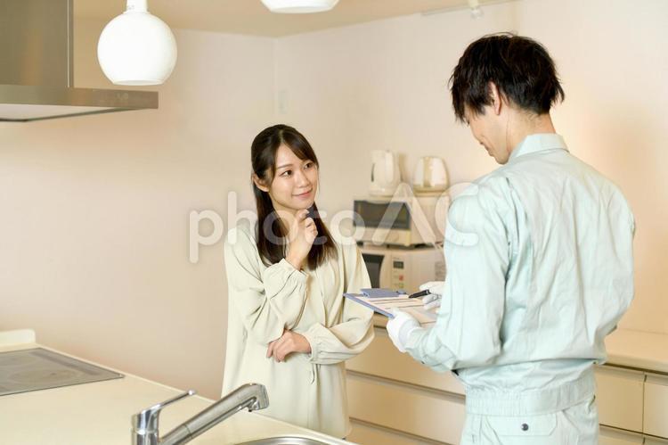 キッチンで会話をする男性作業員と女性客 キッチン,リフォーム,見積もりの写真素材