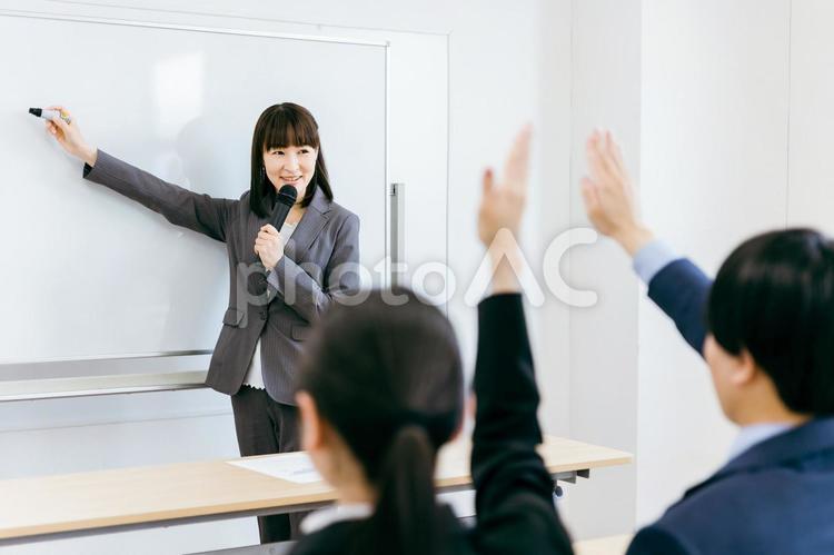 セミナーをする女性講師と挙手する人 ビジネス,セミナー,講師の写真素材
