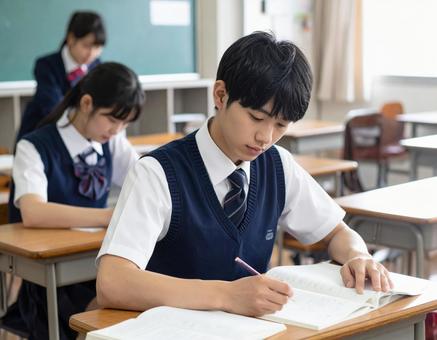 集中して授業に取り組み学習する男子学生 集中して授業に取り組み学習する男子学生の写真