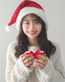 クリスマス プレゼントを持つ女性 クリスマス プレゼントを持つ女性の写真