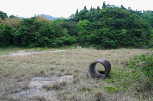 の山を背景にした荒地のコンクリート管 コンクリート管,パイプ,土管の写真素材