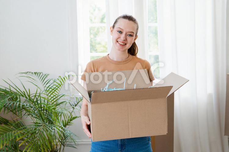 笑顔で段ボールを持つ女性 女性,荷造り,笑顔の写真素材