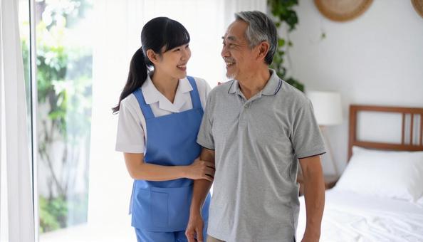 シニア男性の起き上りを補助するヘルパー シニア男性の起き上りを補助するヘルパーの写真