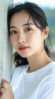 白いTシャツの女性が壁際でポーズをとる 白いTシャツの女性が壁際でポーズをとるの写真