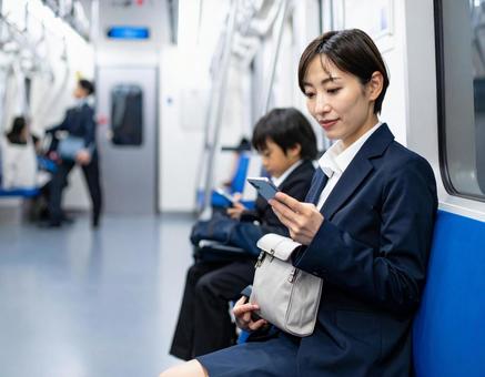ビジネスシーン・地下鉄出張、スマホを見る ビジネスシーン・地下鉄出張、スマホを見るの写真
