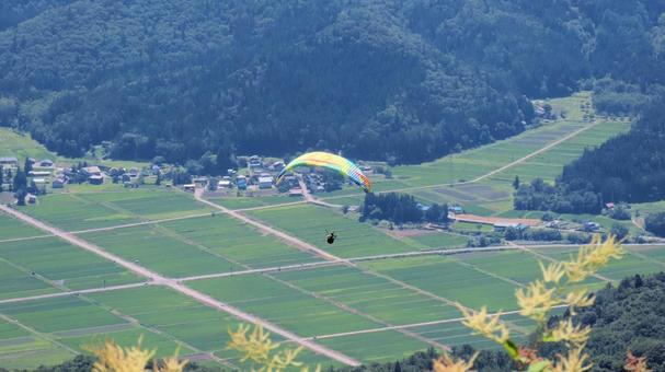 白馬村上空を飛ぶパラグラーダー 白馬村上空を飛ぶパラグラーダー パラグライダー,アクティビティー,夏の写真素材