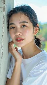 白いTシャツの女性が壁際で微笑む写真 白いTシャツの女性が壁際で微笑む写真の写真