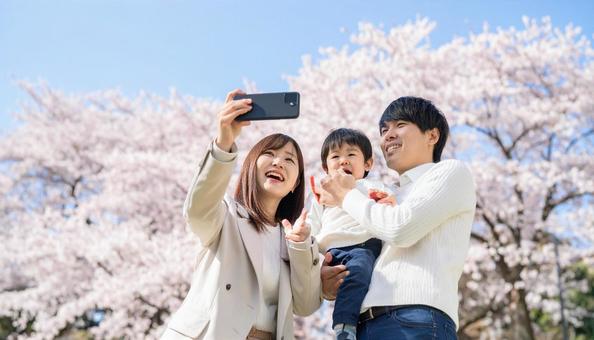 携帯電話で写真を撮る日本人家族 携帯電話で写真を撮る日本人家族の写真