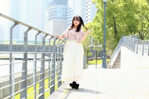 川沿いで景色を眺める女性 川沿いで景色を眺める女性の写真
