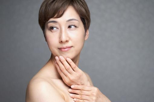 Middle-aged Japanese woman putting her hand on her chin, JPG Middle-aged Japanese woman putting her hand on her chin, JPG