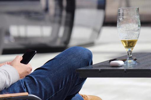 ビールを飲みながら携帯をチェックする男性 ビールを飲みながら携帯をチェックする男性 スマホ,携帯,ビールの写真素材
