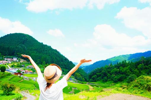 井仁の棚田で深呼吸する女性の後ろ姿 棚田,女性,後ろ姿の写真素材