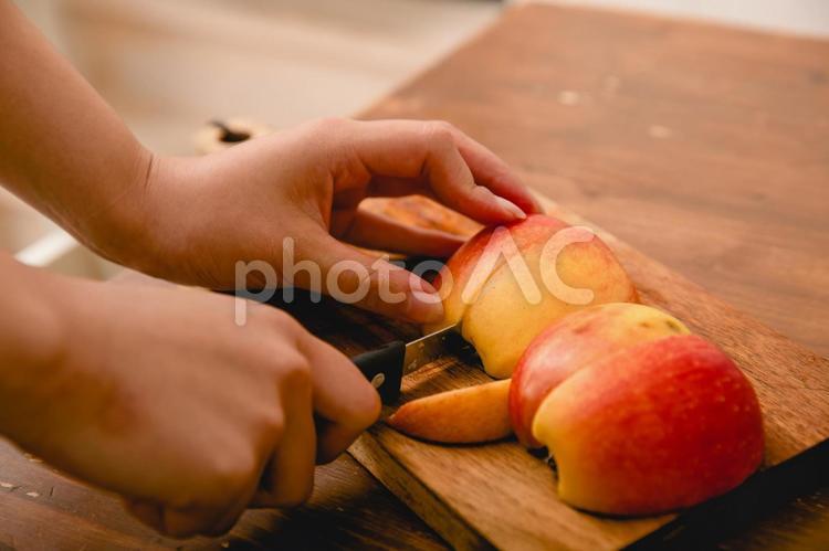 赤いリンゴを切っている手　apple りんご,秋,果物の写真素材