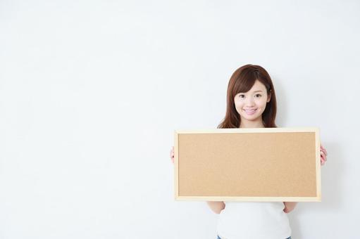 メッセージボードを持つ女性 メッセージボードを持つ女性の写真