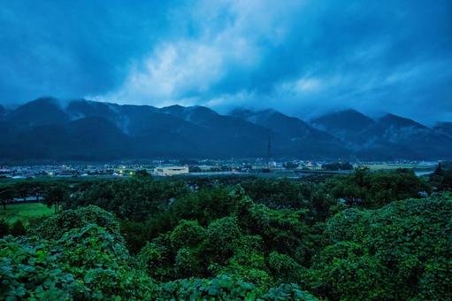 雨上がりの山々、雲が低く垂れ込める田舎町 風景,景色,山の写真素材
