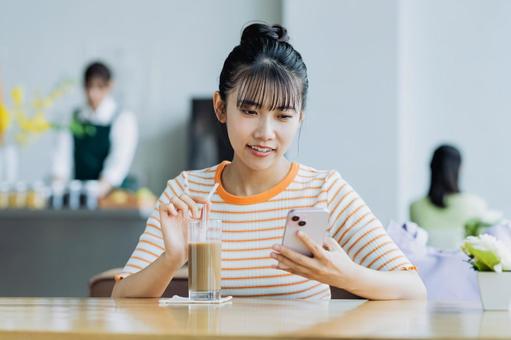 カフェでスマホを見る若い女性 カフェでスマホを見る若い女性 女性,カフェ,人物の写真素材