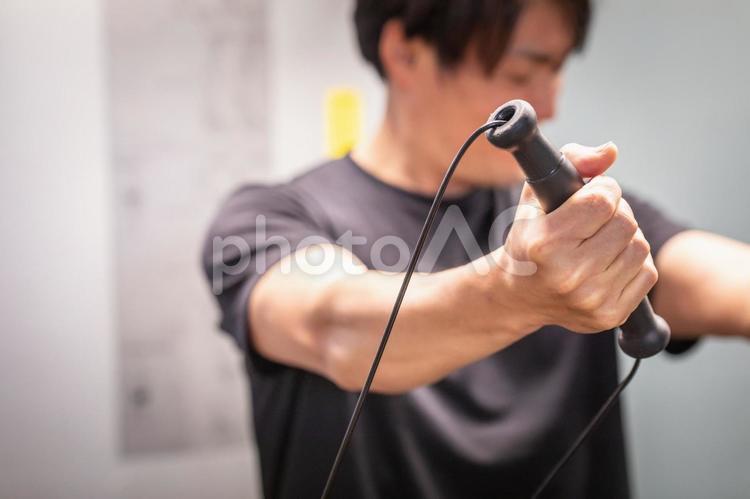 スポーツジムでケーブルマシンを使う男性 ケーブルマシン,ケーブル,ワークアウトの写真素材