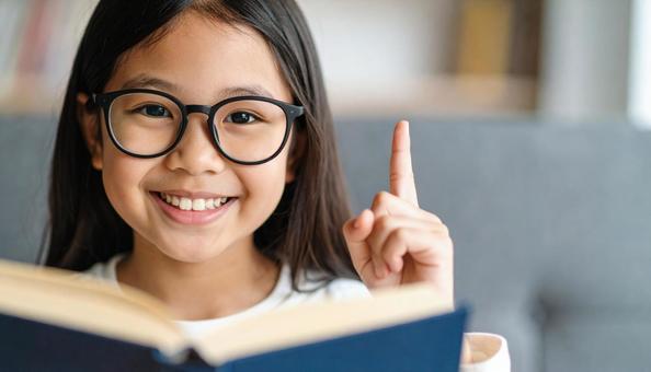 本を読んで疑問解決して笑顔の女の子 本を読んで疑問解決して笑顔の女の子の写真