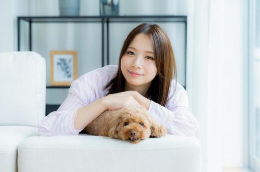 部屋でペットとくつろぐ若い女性 部屋でペットとくつろぐ若い女性 ペット,女性,犬の写真素材