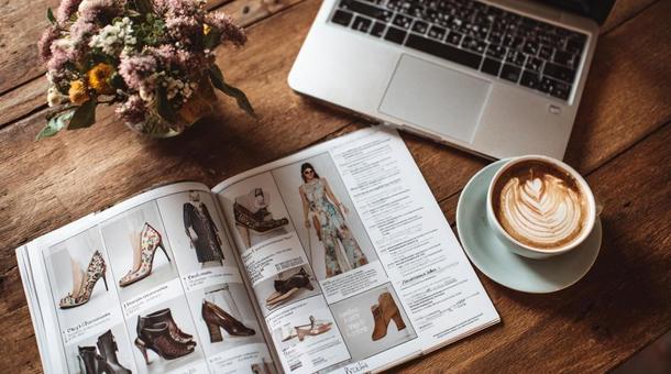 机の上に雑誌と花とパソコンとコーヒー 机の上に雑誌と花とパソコンとコーヒーの写真