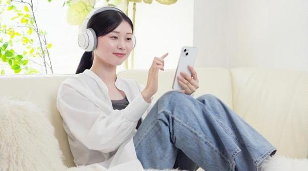 ワイヤレスヘッドフォンで音楽を聞く女性 ワイヤレスヘッドフォンで音楽を聞く女性 女性,ワイヤレス,聴くの写真素材