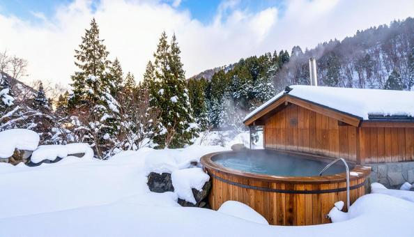 雪山の湯気が立ち上る露天風呂 雪山の湯気が立ち上る露天風呂の写真