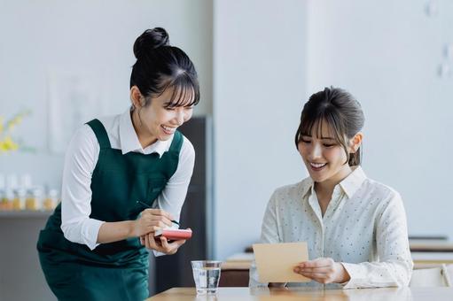 カフェで接客をする若い女性 カフェで接客をする若い女性 カフェ,飲食店,レストランの写真素材