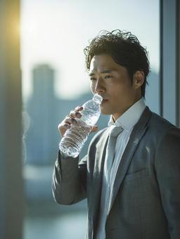 ビジネスシーン：ボトルウォータで喉を潤すの写真