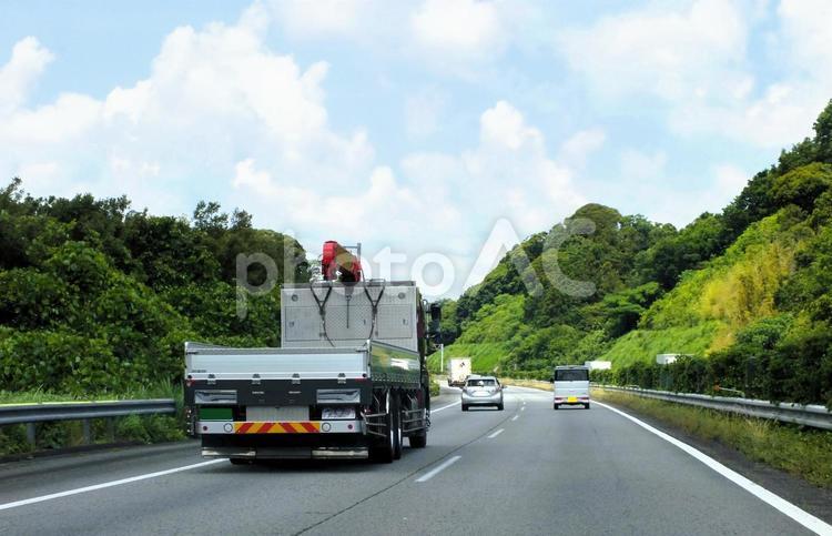 鮮やかな緑の高速を走るクレーンレッカー車 クレーンレッカー車,クレーンレッカー,クレーンの写真素材