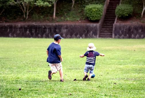 <素材>芝生の公園でサッカーをする兄弟 <素材>芝生の公園でサッカーをする兄弟 子供,男性,人物の写真素材