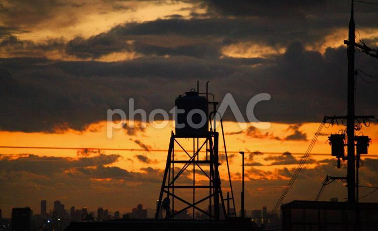 貯水タンクとビル群と電信柱　夕景 貯水タンク,電信柱,電柱の写真素材