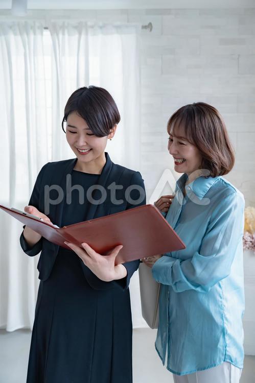 シニア女性とスーツを着た女性 レシェプション,受付,ビジネスウーマンの写真素材