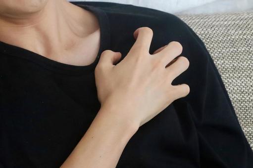 肩を掻く男性 肩を掻く男性の写真