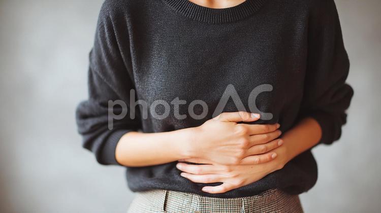 胃の不調を感じる女性の手 腹痛,胃痛,女性の写真素材