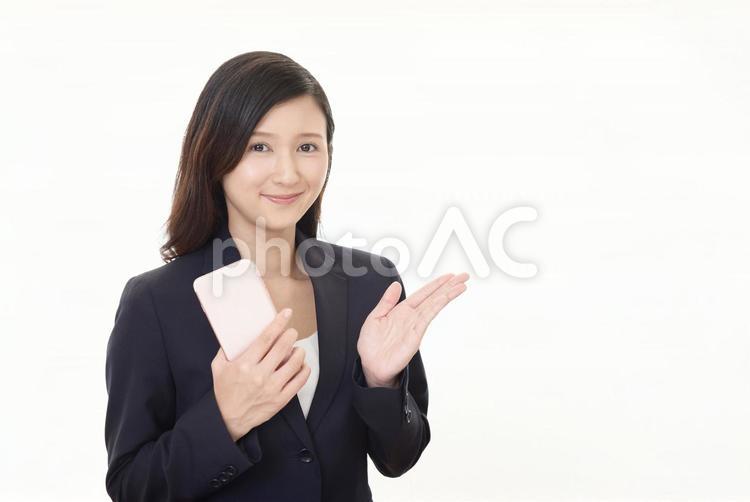 スマートフォンを持つ笑顔のビジネスウーマン 女性,ビジネスウーマン,女の写真素材