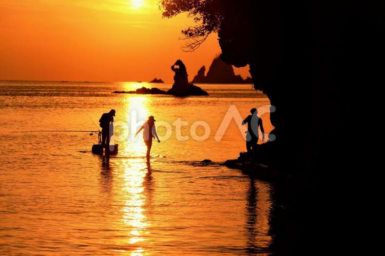釣り人　夕陽日本一の西伊豆町　奇岩に入る 釣り人,夕陽日本一の西伊豆町,夕日の写真素材
