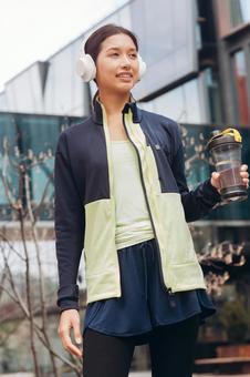 笑顔で飲み物を持っている女性 笑顔で飲み物を持っている女性 女性,ヘッドフォン,飲み物の写真素材