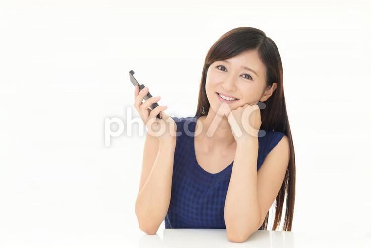 スマートフォンを持つ笑顔の女性 女性,スマートフォン,女の写真素材