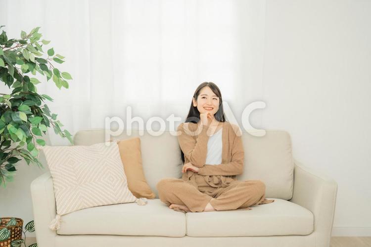 家のソファに座る女性 リビング,女性,ソファの写真素材