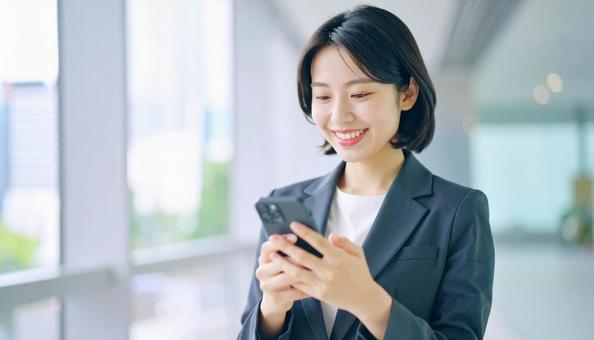 スマホを確認するビジネス女性 スマホを確認するビジネス女性の写真