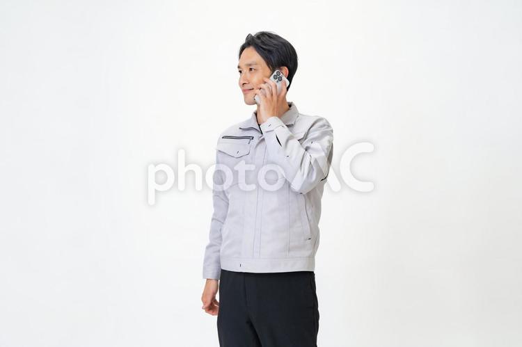 電話をする作業着を着た男性 日本人,点検,保守点検の写真素材